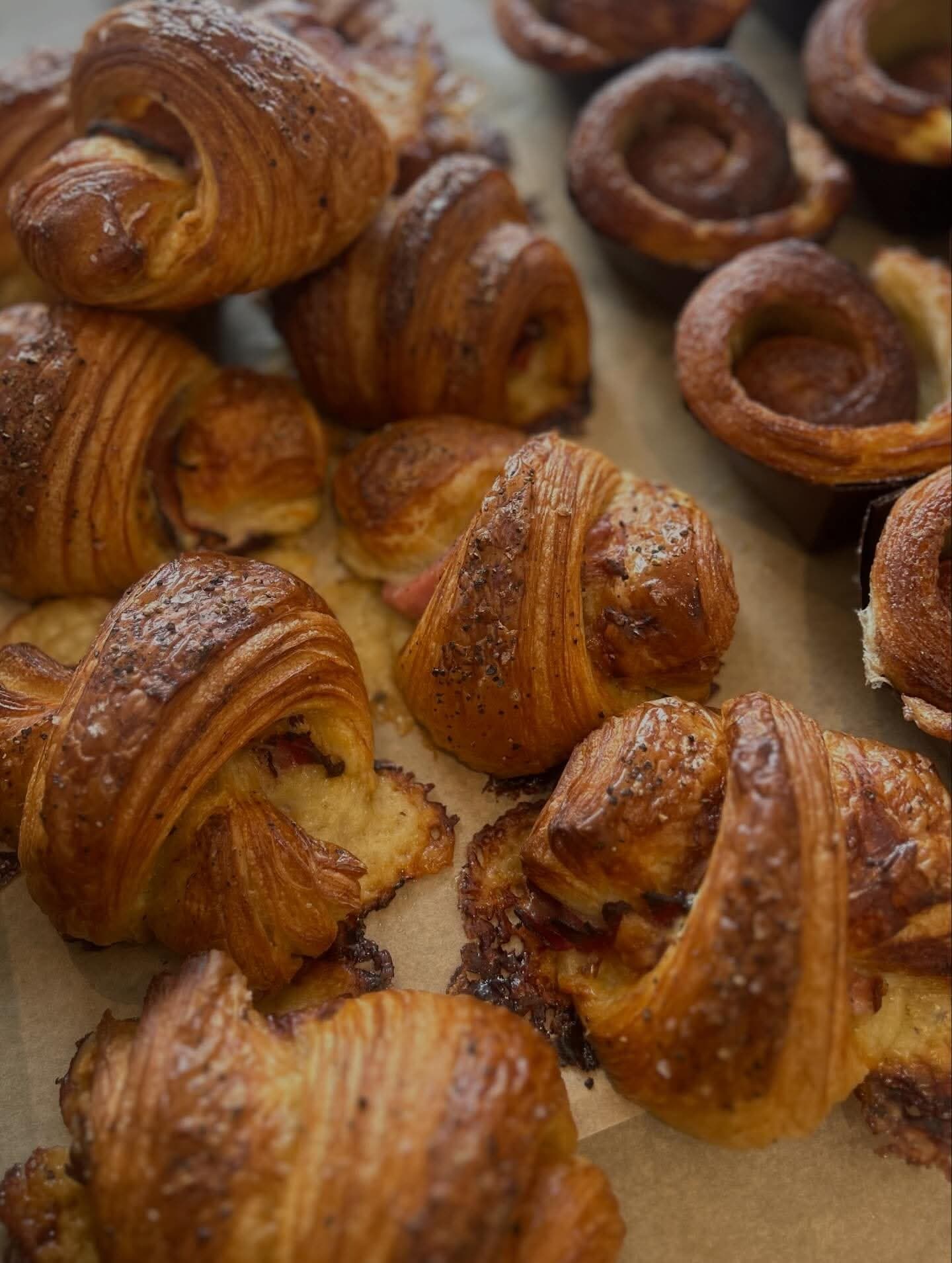 Nybakade smördegsbakverk och kanelsnurror på plåt