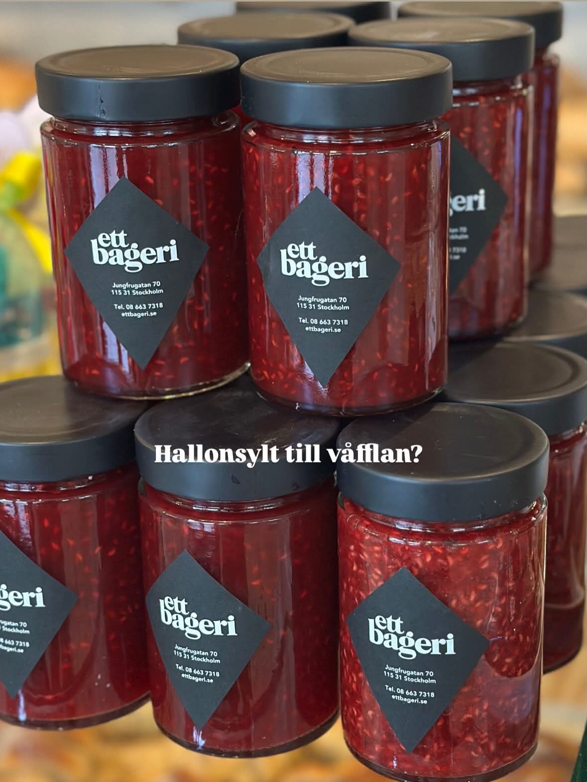 Burkar med hallonsylt med ett bageris diamantetikett